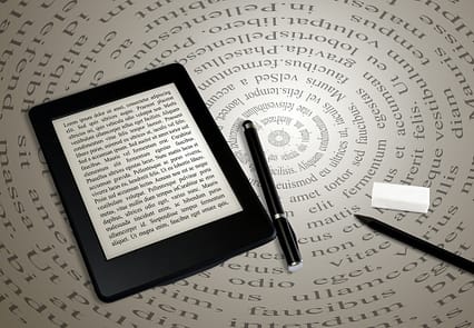 modern ebook reader on book on abstract font background
