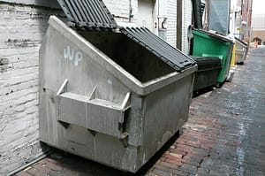 empty grey dumpster in an alleyway