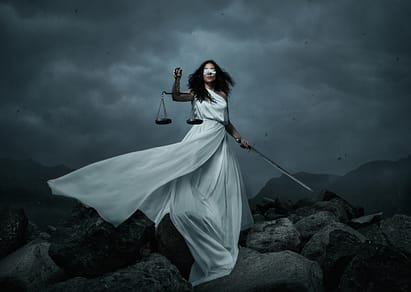 Young fairly woman with scale and sword over the dramatic sky with copy space